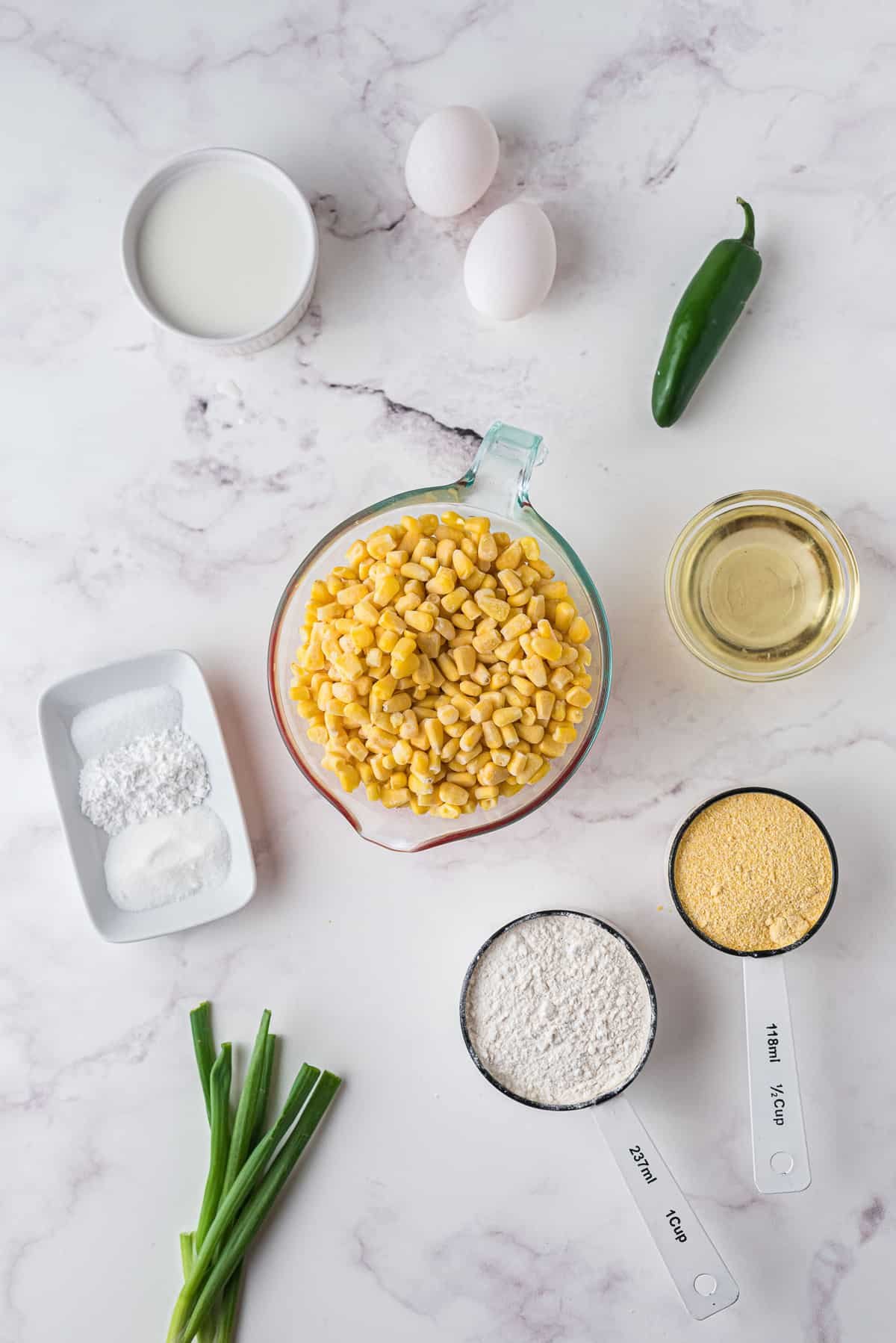 Vista aérea de ingredientes incluyendo granos de maíz, cebolla verde, jalapeño, huevo.