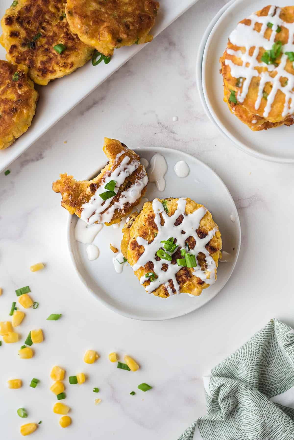 Vista aérea de panqueques rociados con crema agria y espolvoreados con cebollas verdes.